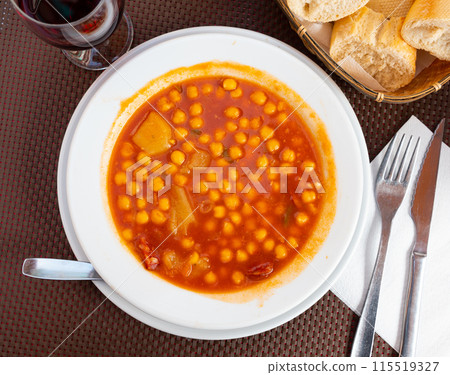 Delicious chickpeas cooked with pieces of chorizo sausage and bacon, onions, garlic, tomatoes, sweet paprika and spices served at plate for dinner. Spanish cuisine Garbanzos con chorizo Delicious chickpeas cooked with pieces of chorizo sausage and bacon, onions, garlic, tomatoes, sweet paprika and spices served at plate for dinner. Spanish cuisine Garbanzos con chorizo 115519327