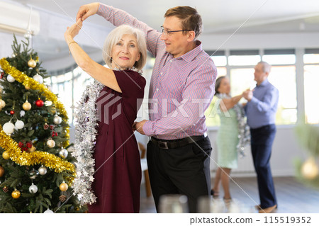 Middle-aged man and elderly woman dancing contemporary discofox in couple in New Year atmosphere 115519352
