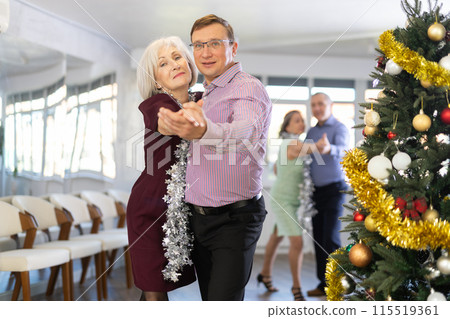 Middle-aged man engaged in dance hall with mature female partner and dances Latin rumba during celebration Christmas. Hobby, healthy lifestyle concept 115519361