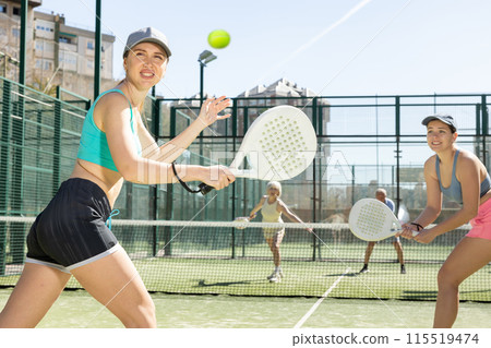 Young woman looking back after the ball while playing Padel Tennis in tennis court Young woman looking back after the ball while playing Padel Tennis in tennis court 115519474
