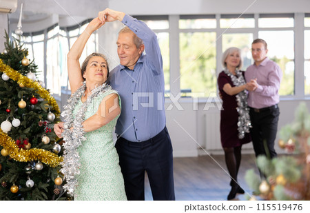 In studio decorated for New Year, elderly man and woman perky dance pair discofox. 115519476