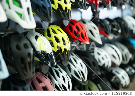 Variety of bicycle helmets displayed in cycling equipment shop 115519568
