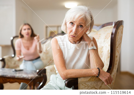 Domestic quarrel between elderly mother and adult daughter in living room 115519614