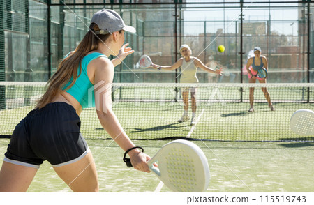 Young woman playing Padel Tennis in pairs in tennis court Young woman playing Padel Tennis in pairs in tennis court 115519743