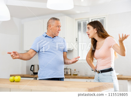 Adult daughter arguing with her mature father in the kitchen Adult daughter arguing with her mature father in the kitchen 115519805