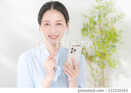 A woman using a smartphone A woman using a smartphone 115520163