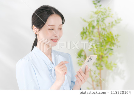 A woman using a smartphone A woman using a smartphone 115520164