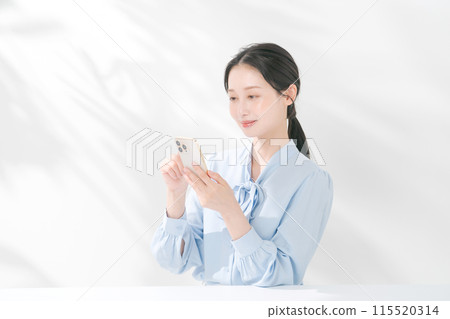 A woman using a smartphone 115520314
