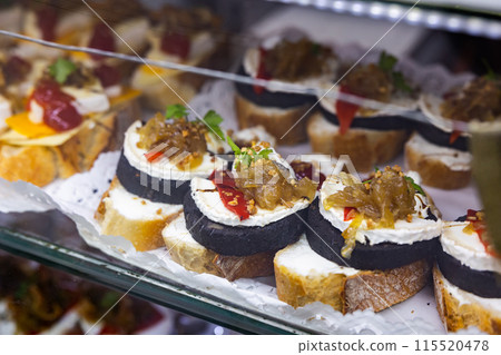 Pinchos with morcilla and creamy cheese in deli case 115520478