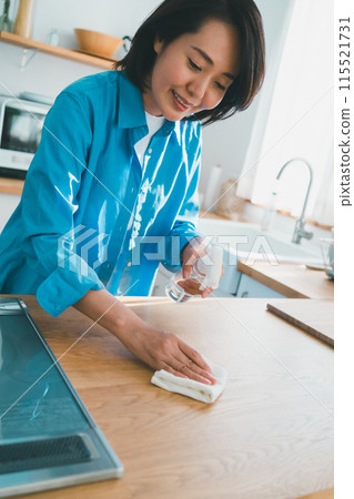 A housewife in her 40s cleaning the kitchen A housewife in her 40s cleaning the kitchen 115521731