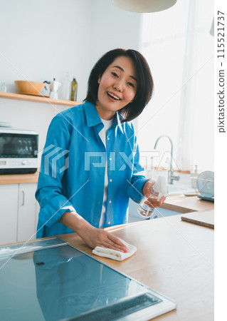 A housewife in her 40s cleaning the kitchen A housewife in her 40s cleaning the kitchen 115521737