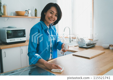A housewife in her 40s cleaning the kitchen A housewife in her 40s cleaning the kitchen 115521741