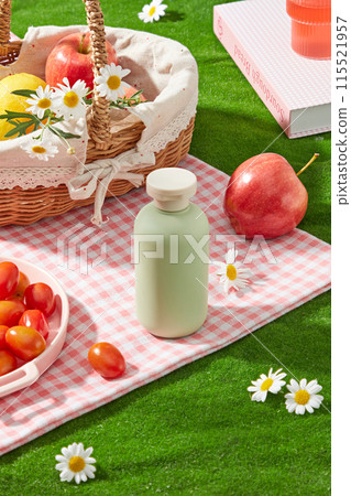 Cosmetic advertising pic of summer picnic layout, green bottle without label featured on pink carpet, fresh fruit and flower decorated around. Blank space for designing, high angle view Cosmetic advertising pic of summer picnic layout, green bottle without label featured on pink carpet, fresh fruit and flower decorated around. Blank space for designing, high angle view 115521957