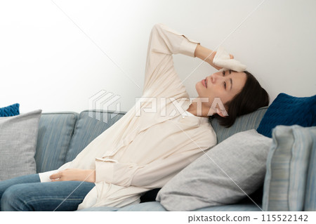 Middle-aged woman wiping sweat, menopause, lying down Middle-aged woman wiping sweat, menopause, lying down 115522142