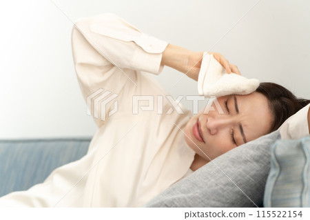 Middle-aged woman wiping sweat, menopause, lying down Middle-aged woman wiping sweat, menopause, lying down 115522154