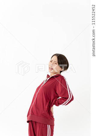 Woman in tracksuit with back pain 115522452