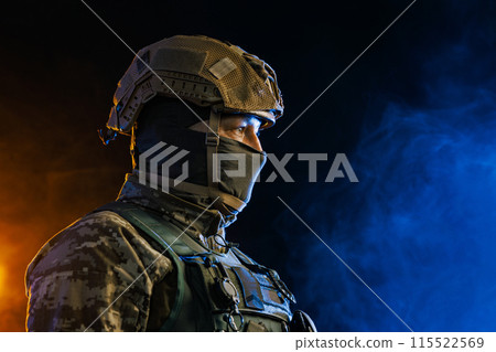 Portrait of a Tactical Soldier in Combat Gear against an Intense Orange and Blue Background Portrait of a Tactical Soldier in Combat Gear against an Intense Orange and Blue Background 115522569
