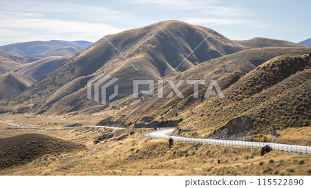 Curvy road leading through high mountain pass with autumn colors in Lindis Pass, New Zealand 115522890