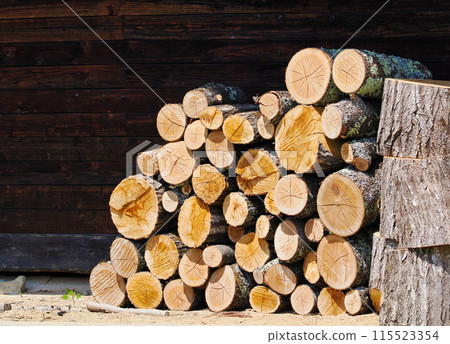 Firewood logs stacked outside a house 115523354