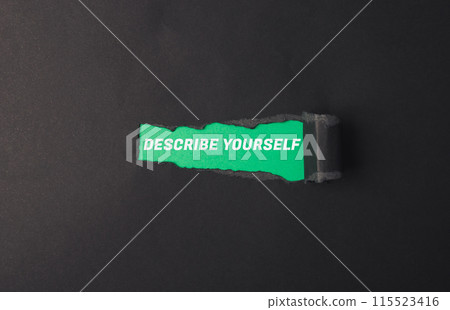 A torn piece of paper with the words describe yourself written on it 115523416