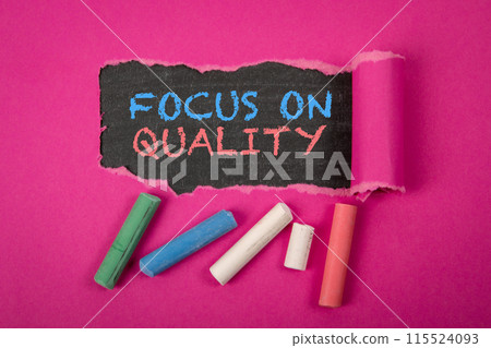 FOCUS ON QUALITY. Text under torn purple paper on a blackboard FOCUS ON QUALITY. Text under torn purple paper on a blackboard 115524093