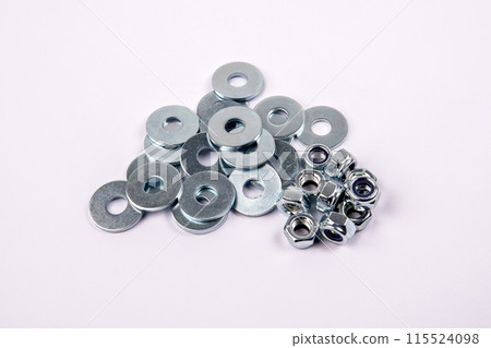 Bunch of flat washer and zinc plated hexagon nuts on white background Bunch of flat washer and zinc plated hexagon nuts on white background 115524098