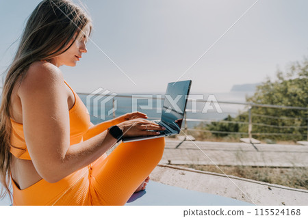 Woman laptop sea. Working remotely on seashore. Happy successful woman female freelancer working on laptop by the sea at sunset, makes a business transaction online. Freelance, remote work on vacation 115524168