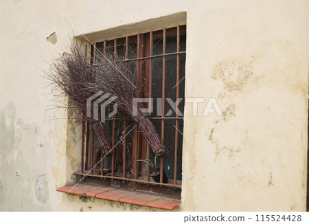 the old window behind the bars. twig broom 115524428
