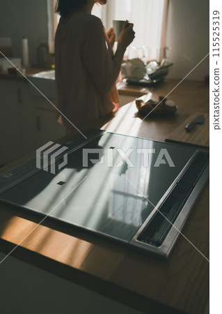 A housewife eating breakfast standing up in the kitchen 115525319
