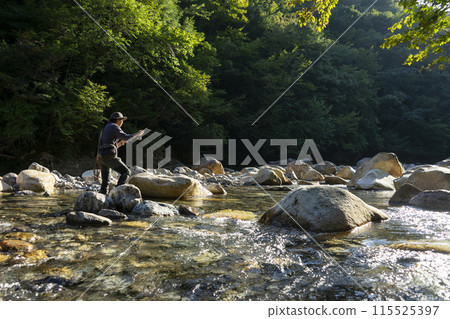 A man who enjoys fly fishing A man who enjoys fly fishing 115525397