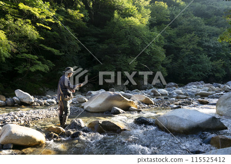 A man who enjoys fly fishing A man who enjoys fly fishing 115525412