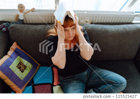 portrait middle-aged woman reading book while sitting on sofa portrait middle-aged woman reading book while sitting on sofa 115525427