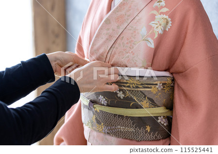 一個穿著和服的女人正在穿衣服 一個穿著和服的女人正在穿衣服 115525441