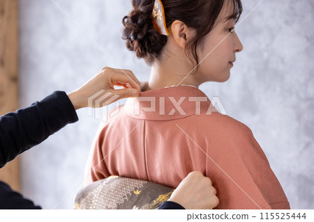 一個穿著和服的女人正在穿衣服 一個穿著和服的女人正在穿衣服 115525444
