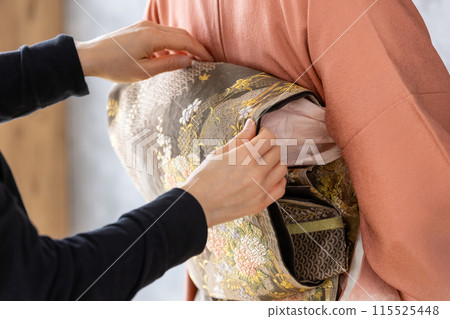 一個穿著和服的女人正在穿衣服 一個穿著和服的女人正在穿衣服 115525448
