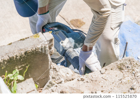 Air hammer Air chipper A worker using an air chipping hammer to break down a concrete block Air chipper Air hammer Air chipper A worker using an air chipping hammer to break down a concrete block Air chipper 115525870