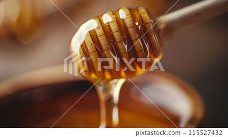 Capture a close-up shot of honey dripping from a wooden honey dipper 115527432