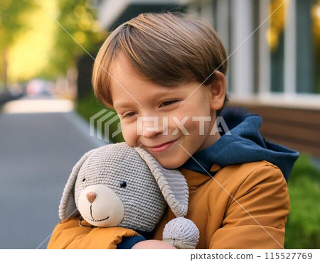 Boy hugging a stuffed rabbit 115527769