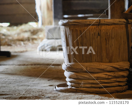 Old wooden barrels and hoops placed in the dirt floor 115528170