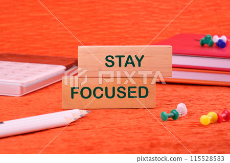 Concept words Stay focused written on a wooden block in a composition with business accessories Concept words Stay focused written on a wooden block in a composition with business accessories 115528583