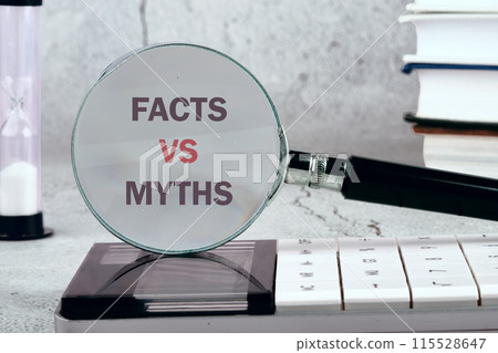 Business, financial and fact vs myth concept. Copy space. Fact vs myth symbol, Concept words through a magnifying glass on a gray background. Black and white image 115528647