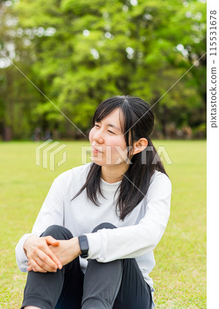 Women in their twenties sitting on the lawn Women in their twenties sitting on the lawn 115531678