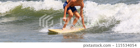 Young man surfing in bright sunshine Young man surfing in bright sunshine 115534054