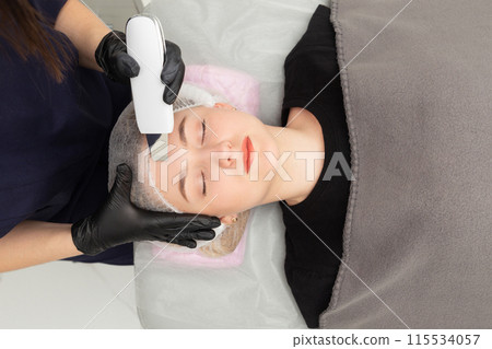 Young woman getting ultrasonic peel skin with skin scrubber. Young woman getting ultrasonic peel skin with skin scrubber. 115534057