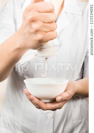 cosmetician cream squeezes out of a tube cosmetician cream squeezes out of a tube 115534091