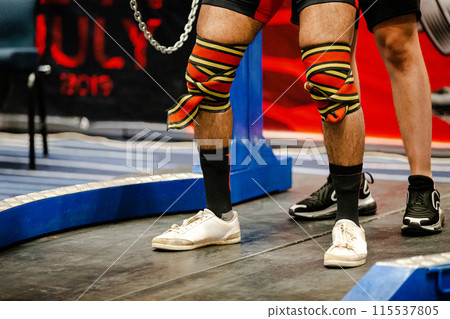 elastic wrap bandage on knees powerlifter athlete, powerlifting competition elastic wrap bandage on knees powerlifter athlete, powerlifting competition 115537805