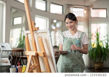 Talented Artist Painting in Bright Workshop. Creative Process in Modern Art Studio with Natural Light and Artistic Tools Talented Artist Painting in Bright Workshop. Creative Process in Modern Art Studio with Natural Light and Artistic Tools 115538183