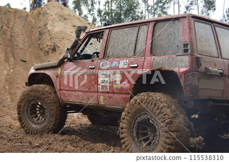 a red SUV in the mud accelerates to overcome obstacles. Off-road competition for SUVs. a red SUV in the mud accelerates to overcome obstacles. Off-road competition for SUVs. 115538310