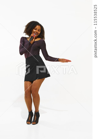 Charismatic performer, young woman singing in microphone, performing solo isolated on white background 115538525