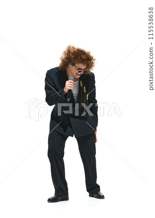 Concert Energy. Full-length image of young emotional man singer in black suit performing isolated on white background Concert Energy. Full-length image of young emotional man singer in black suit performing isolated on white background 115538638